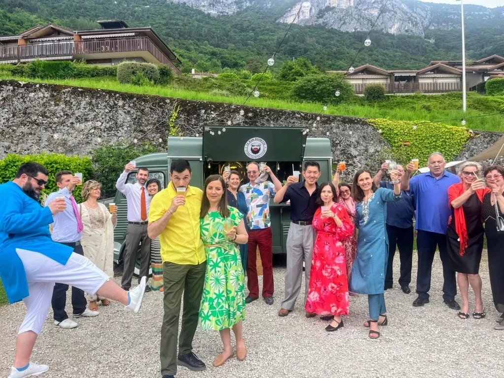 groupe de personne qui prend la pose un verre de bière à la main en arrière plan le bar mobile le bar bichette.