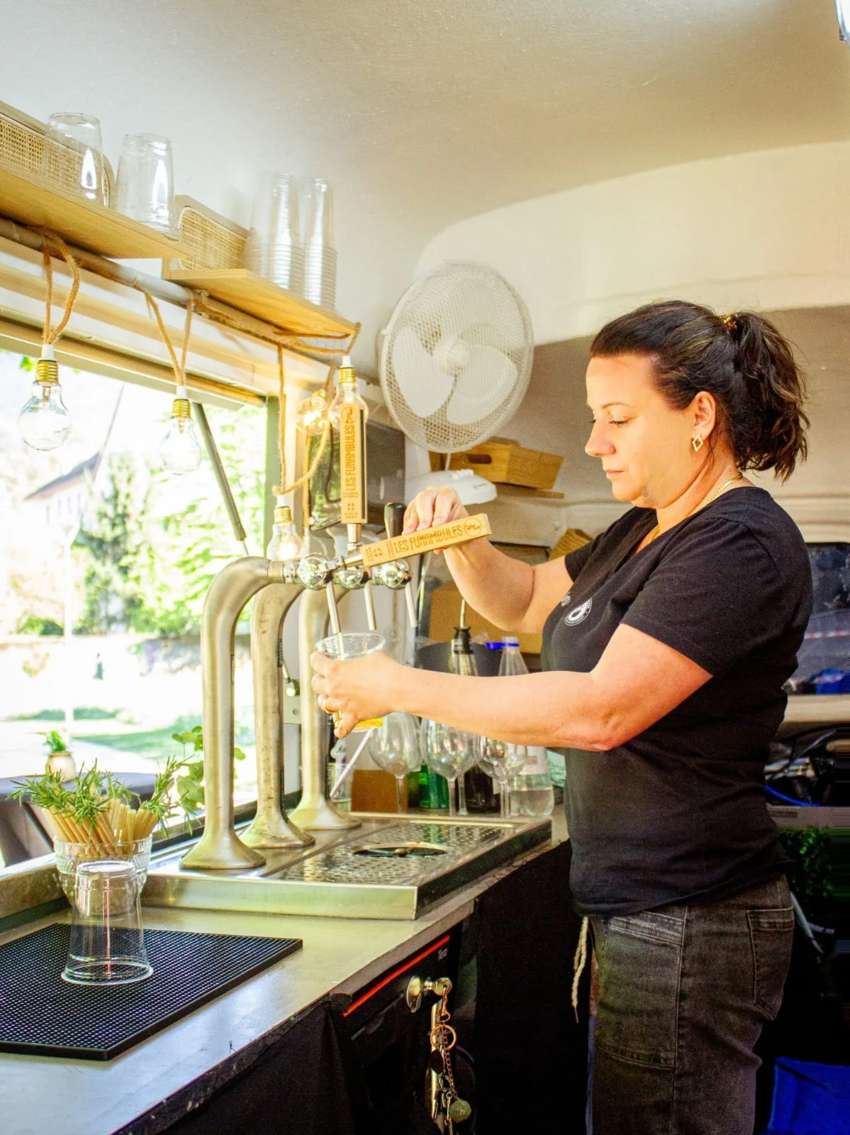 Jeanne propriétaire du bar mobile le Bar bichette en train de tirer une bière pour servir ses clients